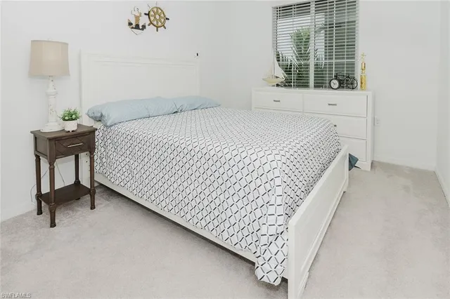 a bedroom with a bed and a white cabinet