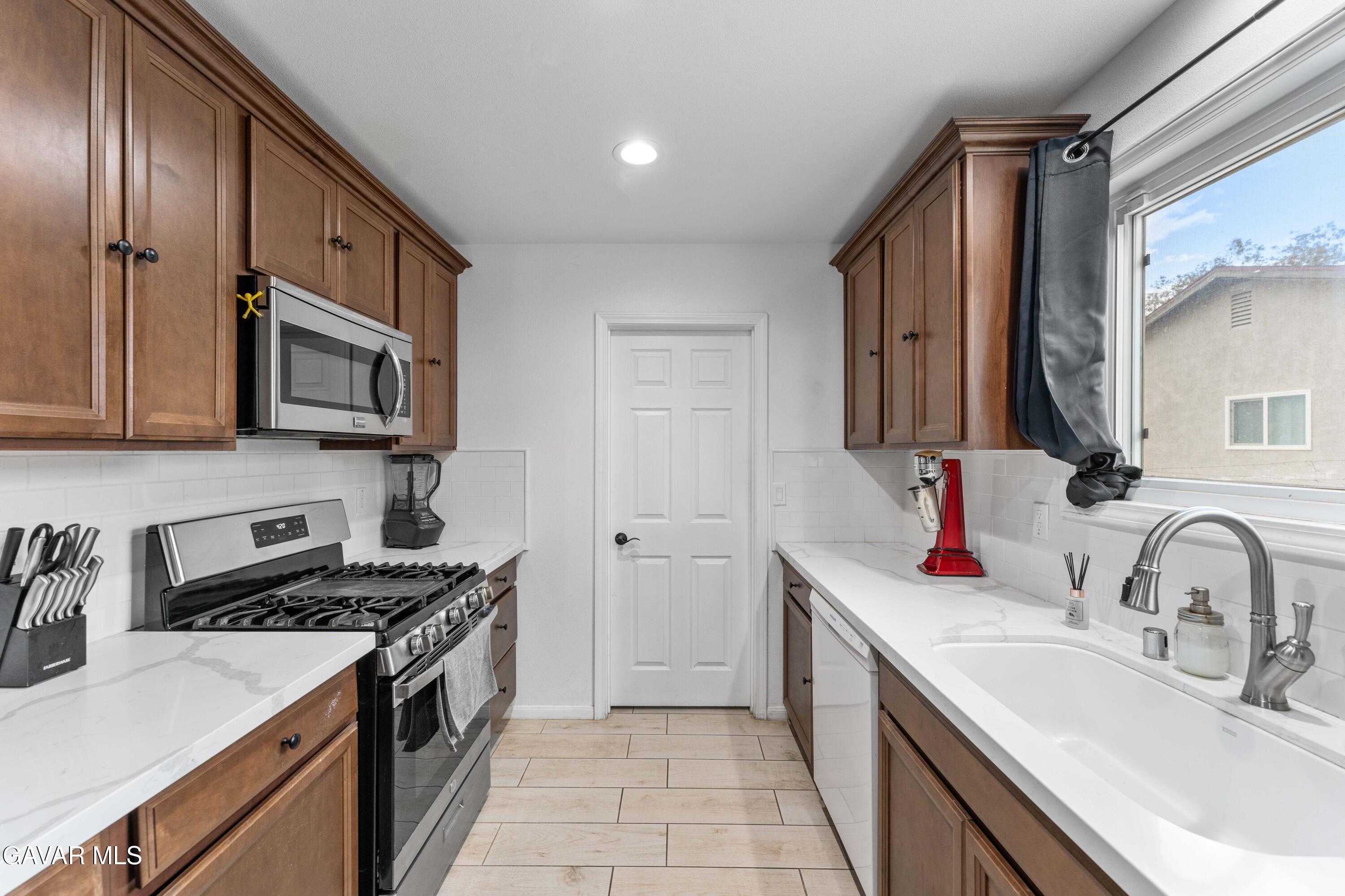 5237 West Ave L8 Lancaster, CA 93536 - Photo 11 of 38 a kitchen with stainless steel appliances granite countertop a sink stove and refrigerator