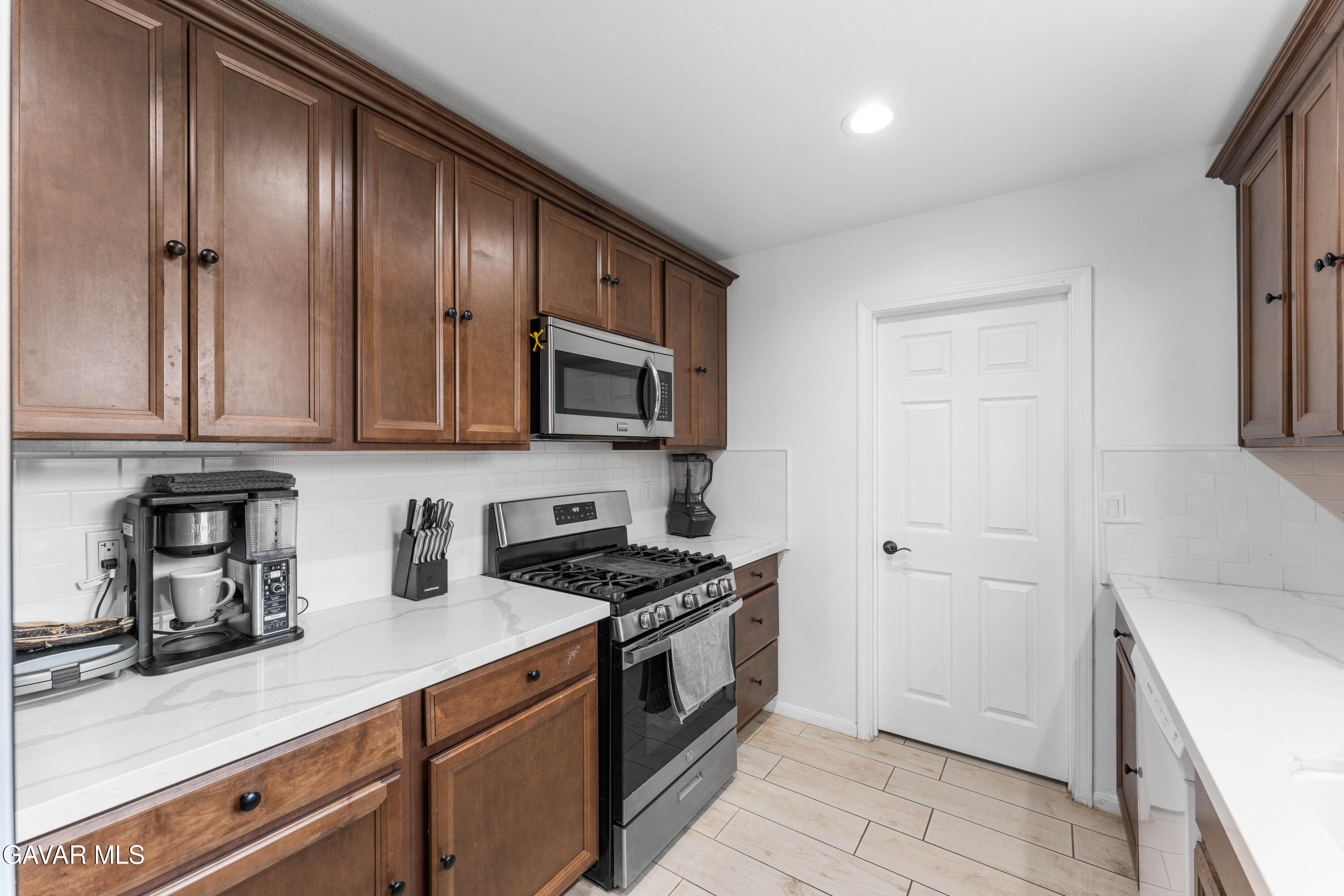 5237 West Ave L8 Lancaster, CA 93536 - Photo 12 of 38 a kitchen with stainless steel appliances a stove a microwave and cabinets