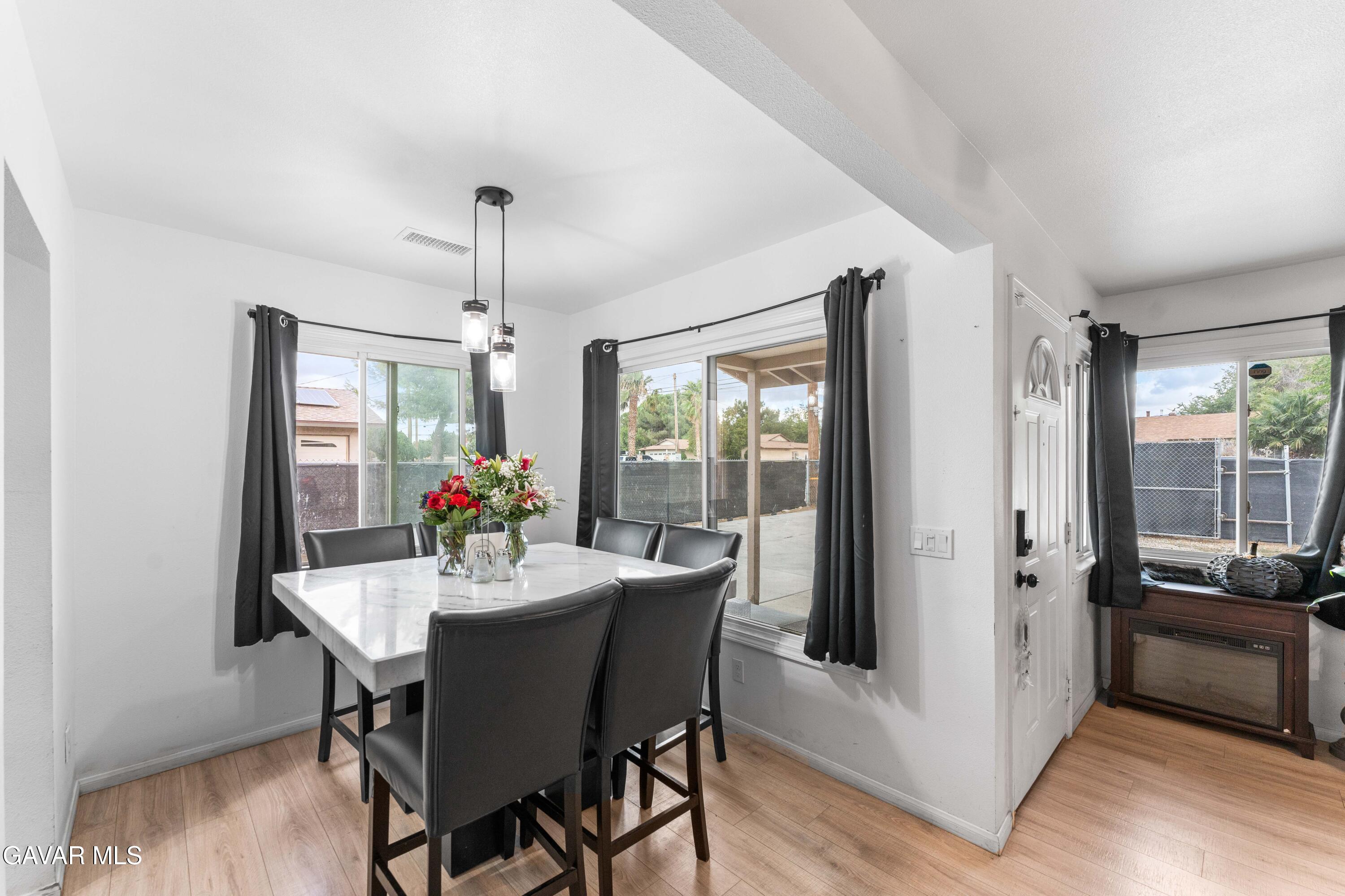 5237 West Ave L8 Lancaster, CA 93536 - Photo 16 of 38 a dining room with furniture a chandelier and wooden floor
