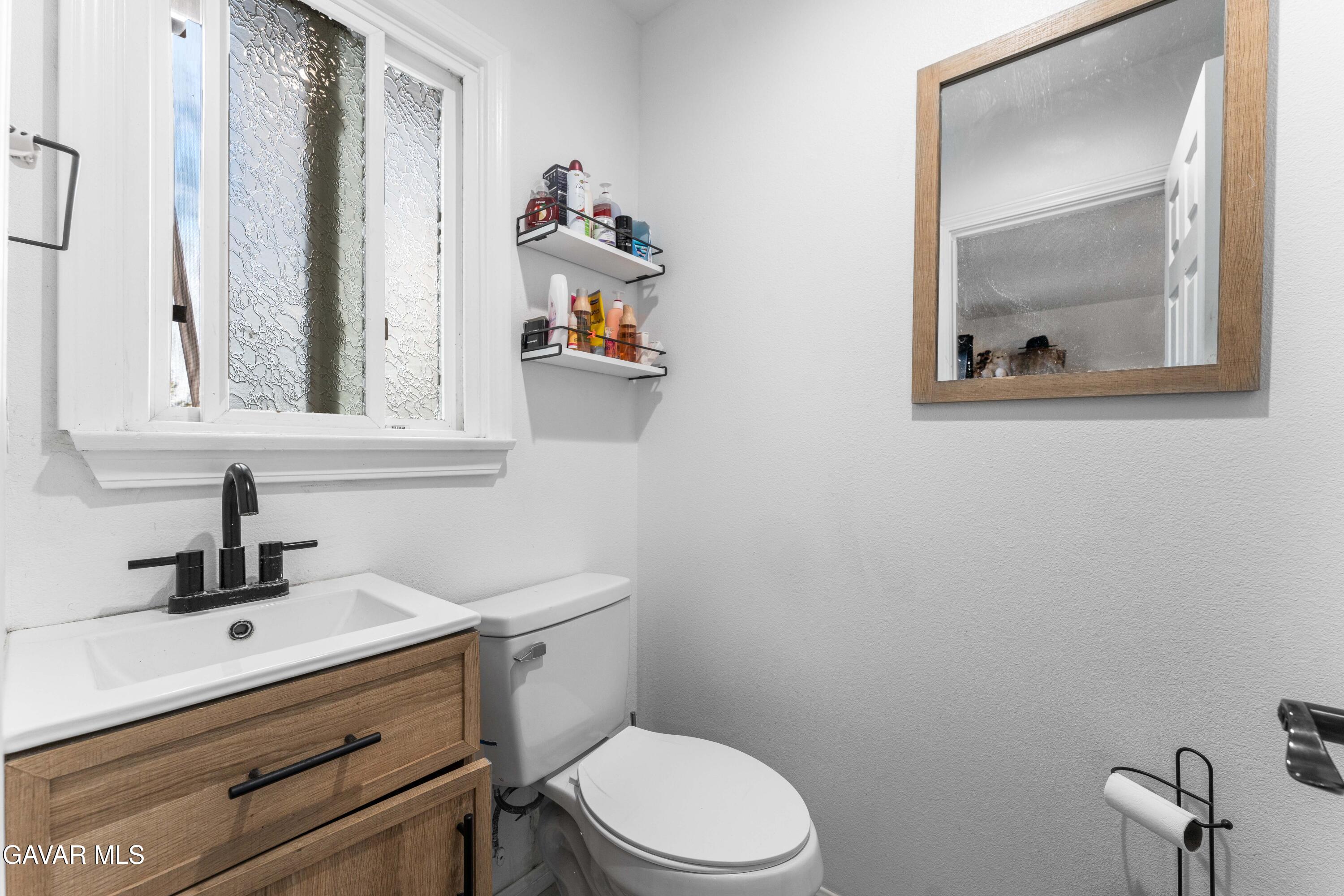5237 West Ave L8 Lancaster, CA 93536 - Photo 19 of 38 a bathroom with a toilet sink and mirror