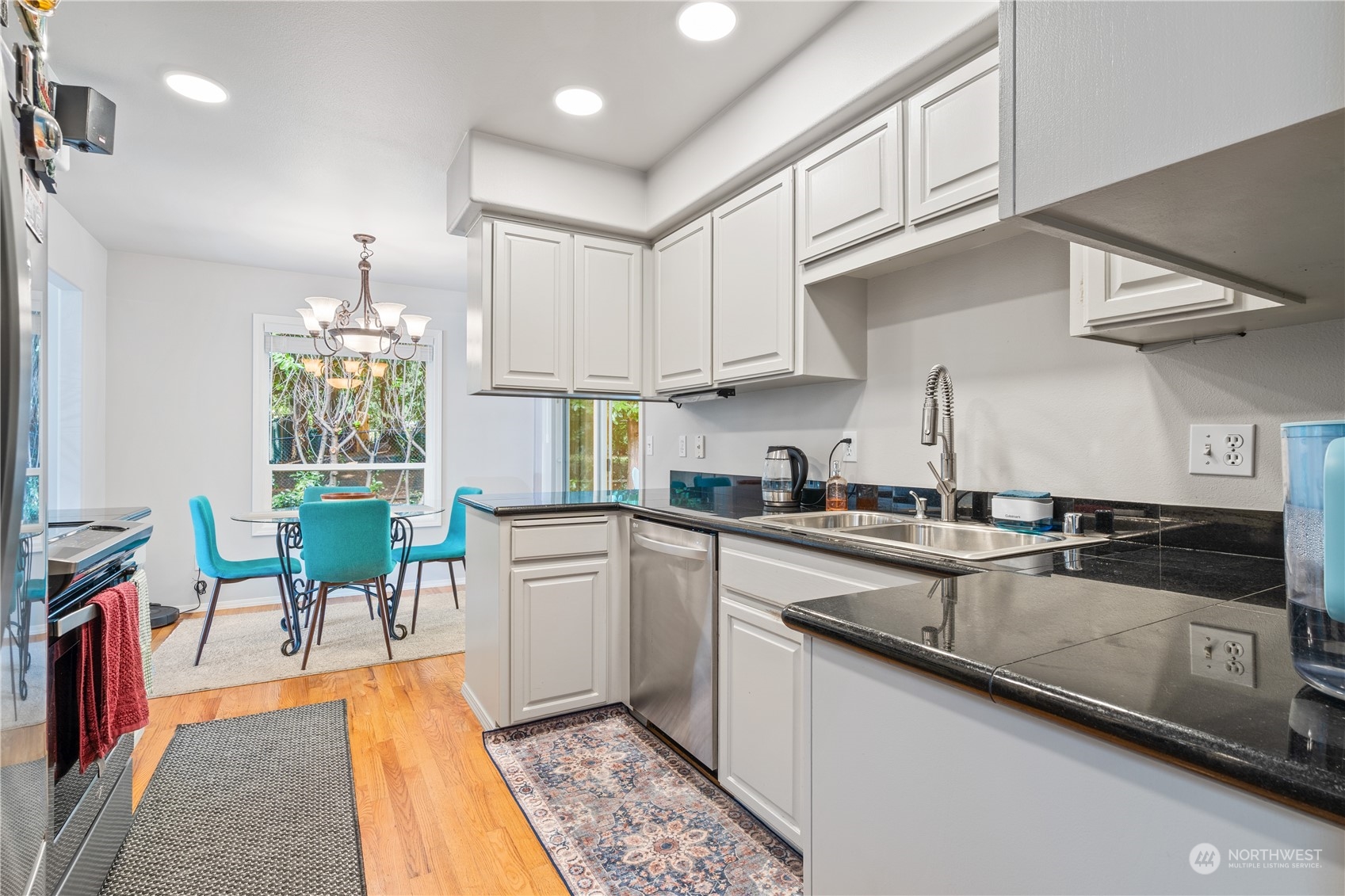 19318 2nd Drive Southeast, Unit B Bothell, WA 98012 - Photo 3 of 28 a kitchen with stainless steel appliances granite countertop a sink dishwasher a stove a refrigerator and cabinets with wooden floor