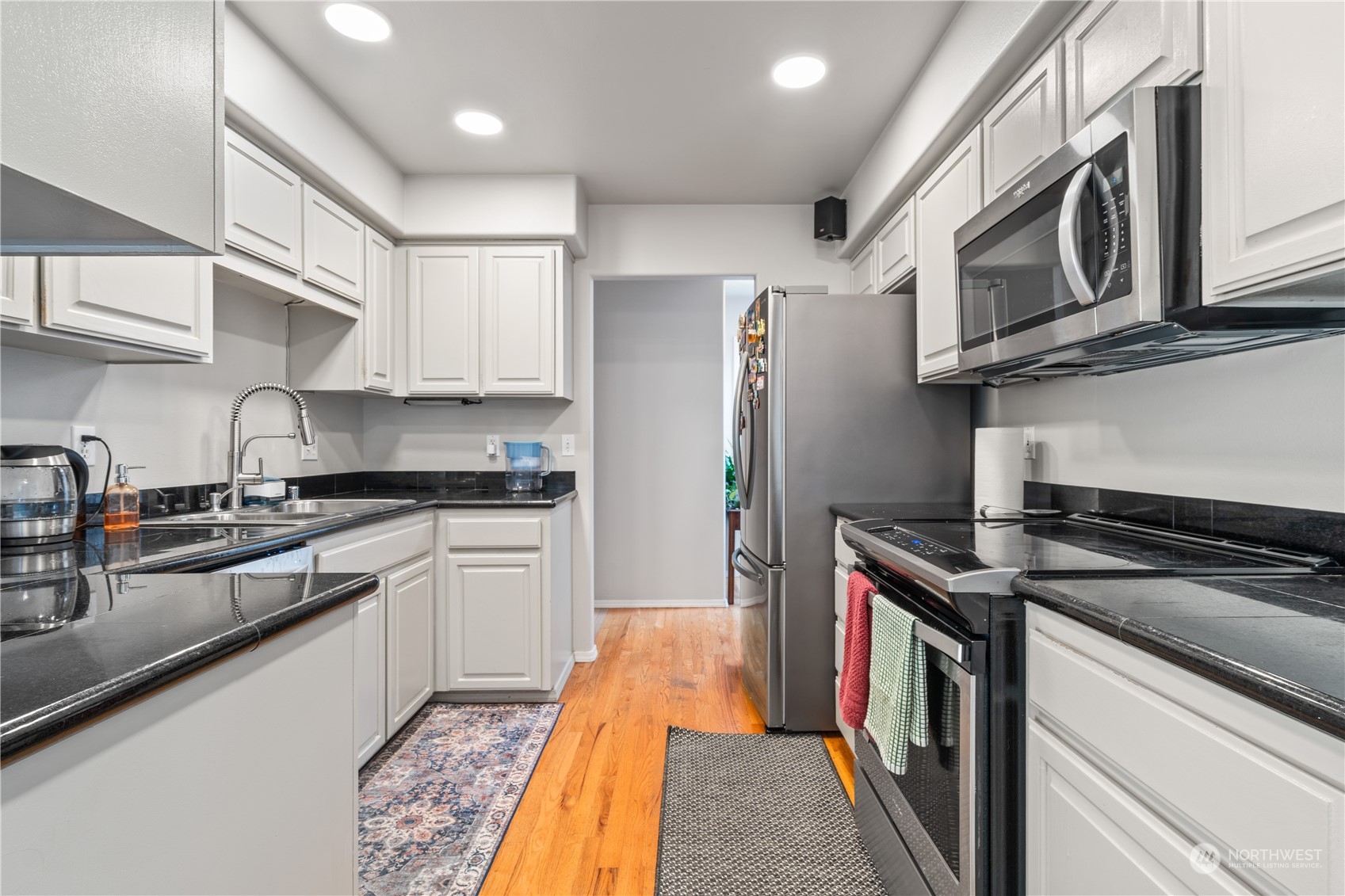 19318 2nd Drive Southeast, Unit B Bothell, WA 98012 - Photo 4 of 28 a kitchen with stainless steel appliances granite countertop a refrigerator a stove and a sink with wooden floor