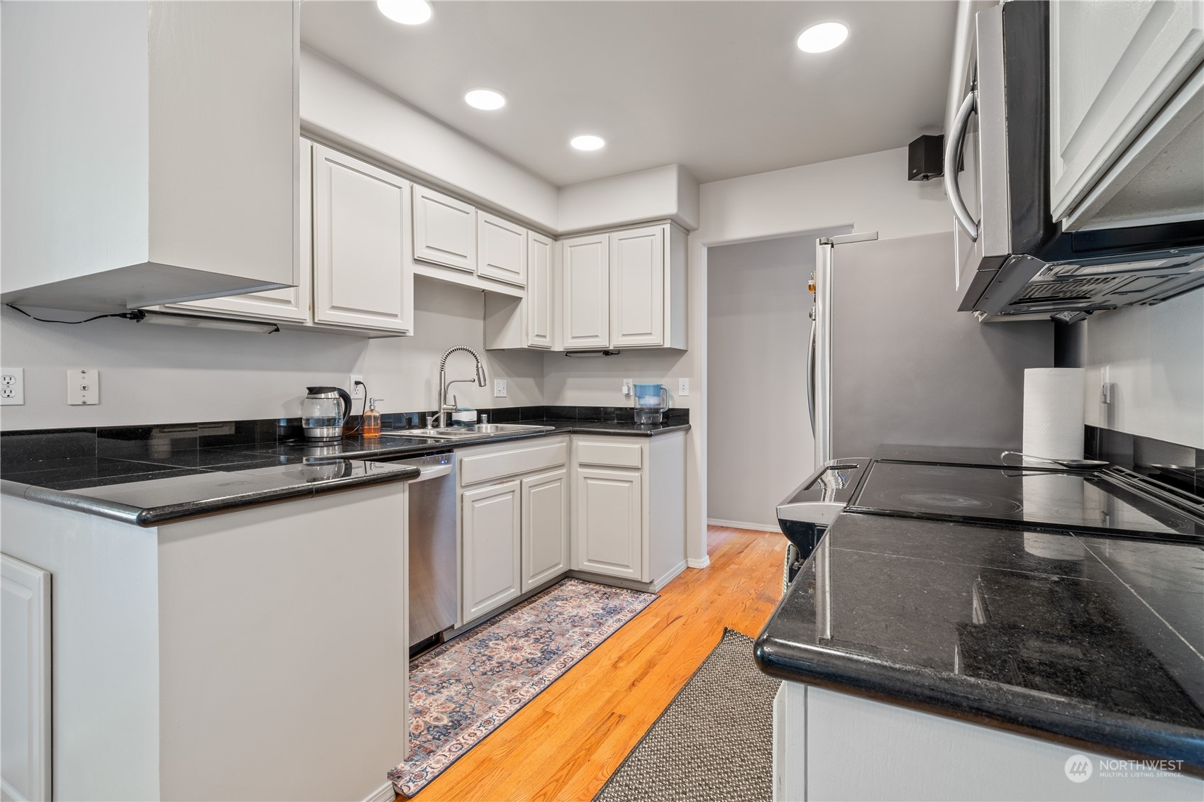 19318 2nd Drive Southeast, Unit B Bothell, WA 98012 - Photo 5 of 28 a kitchen with stainless steel appliances granite countertop a sink a stove and a refrigerator