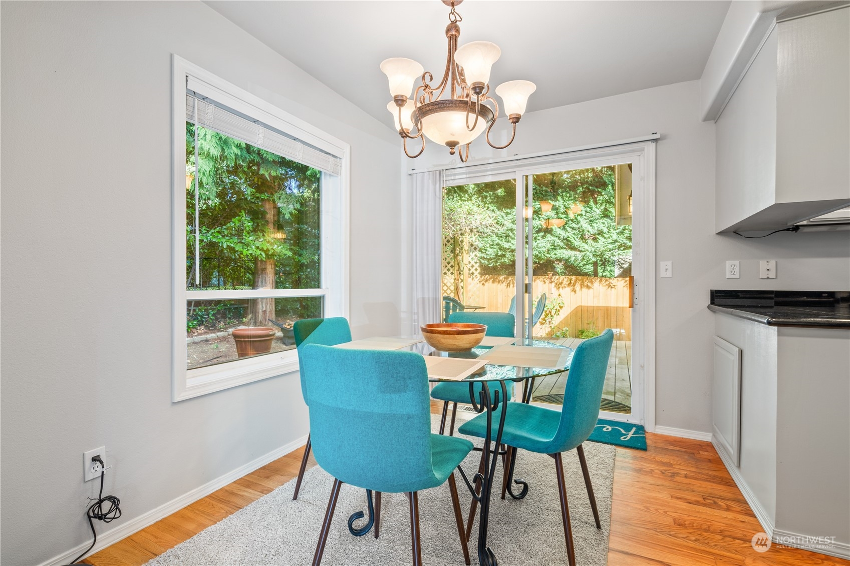 19318 2nd Drive Southeast, Unit B Bothell, WA 98012 - Photo 9 of 28 a dining room with wooden floor a chandelier a wooden table and chairs