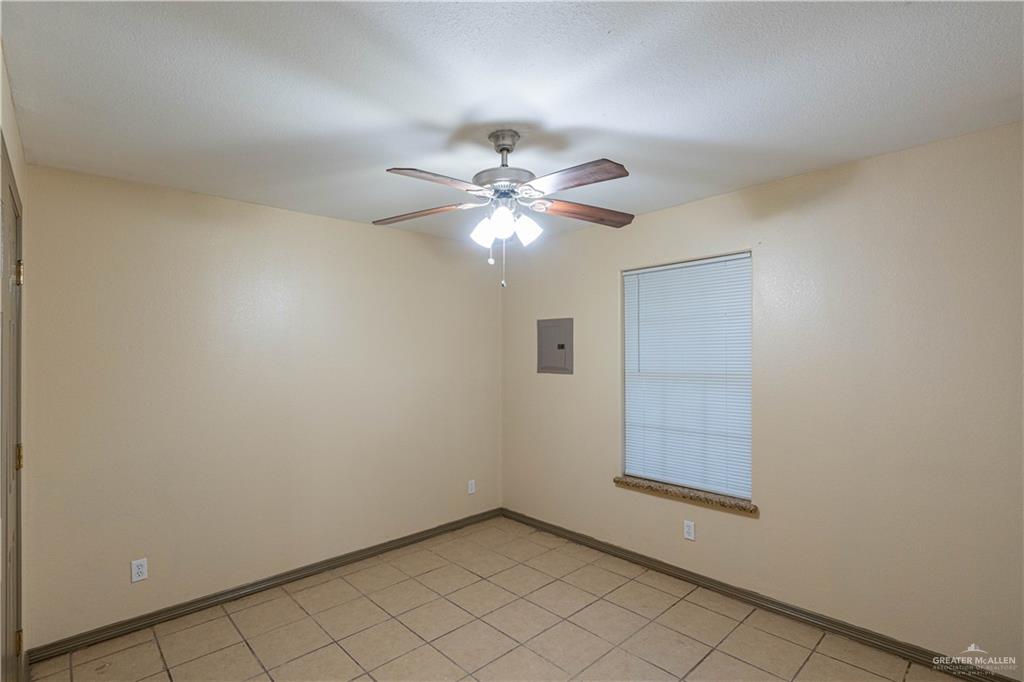 17002 Queen Palm Drive, Unit C Penitas, TX 78576 - Photo 7 of 10 Spare room featuring a ceiling fan, electric panel, and light tile patterned floors