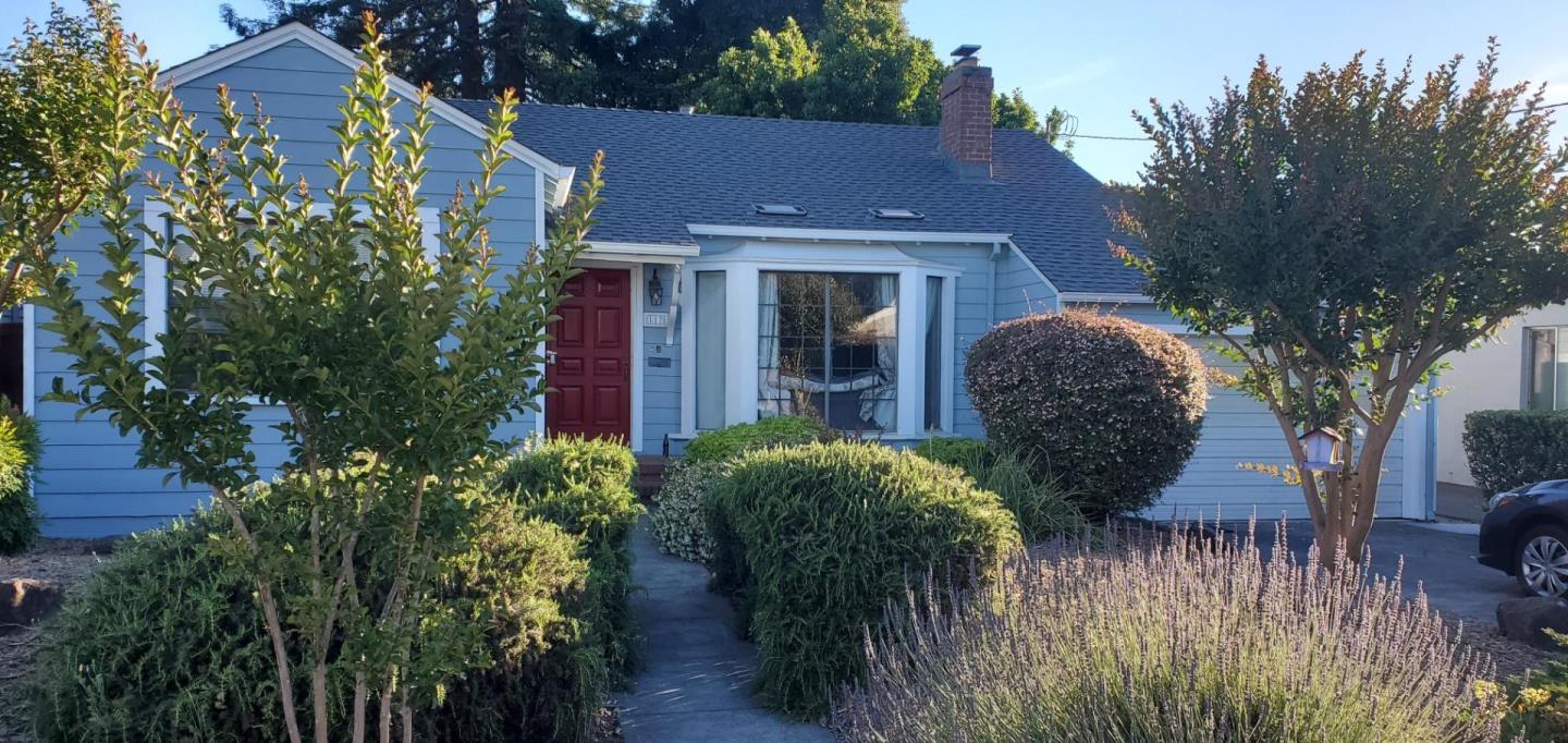 a view of a house with wooden fence and potted plants