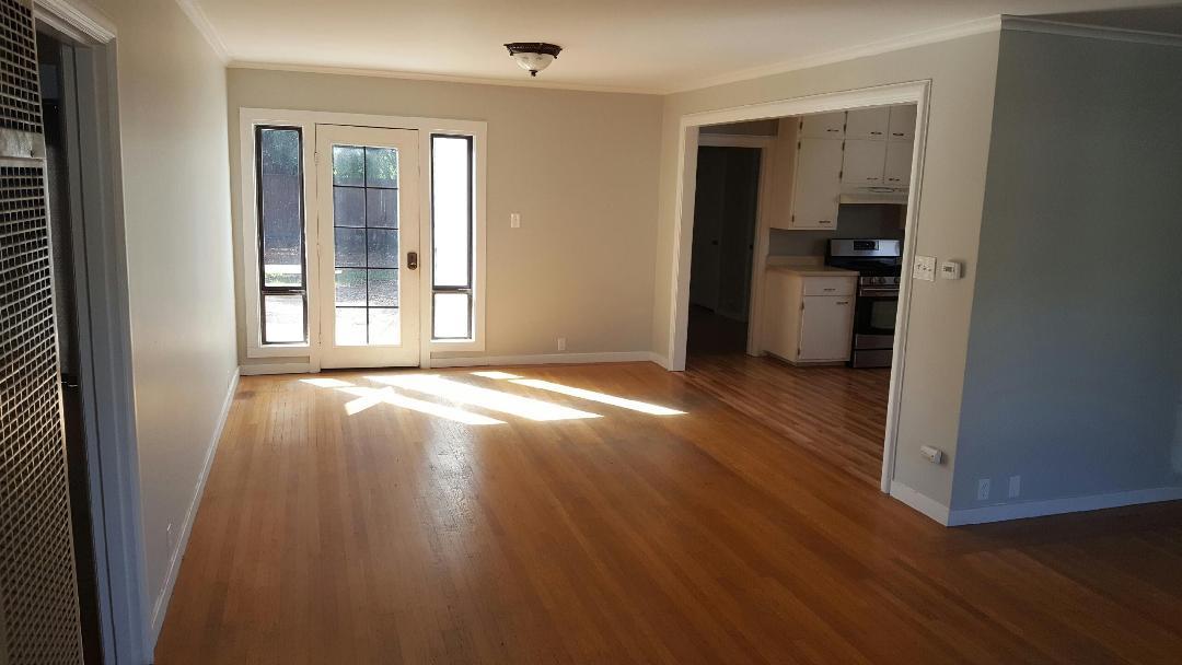 117 Talbot Avenue Santa Rosa, CA 95404 - Photo 5 of 7 an empty room with wooden floor and a kitchen