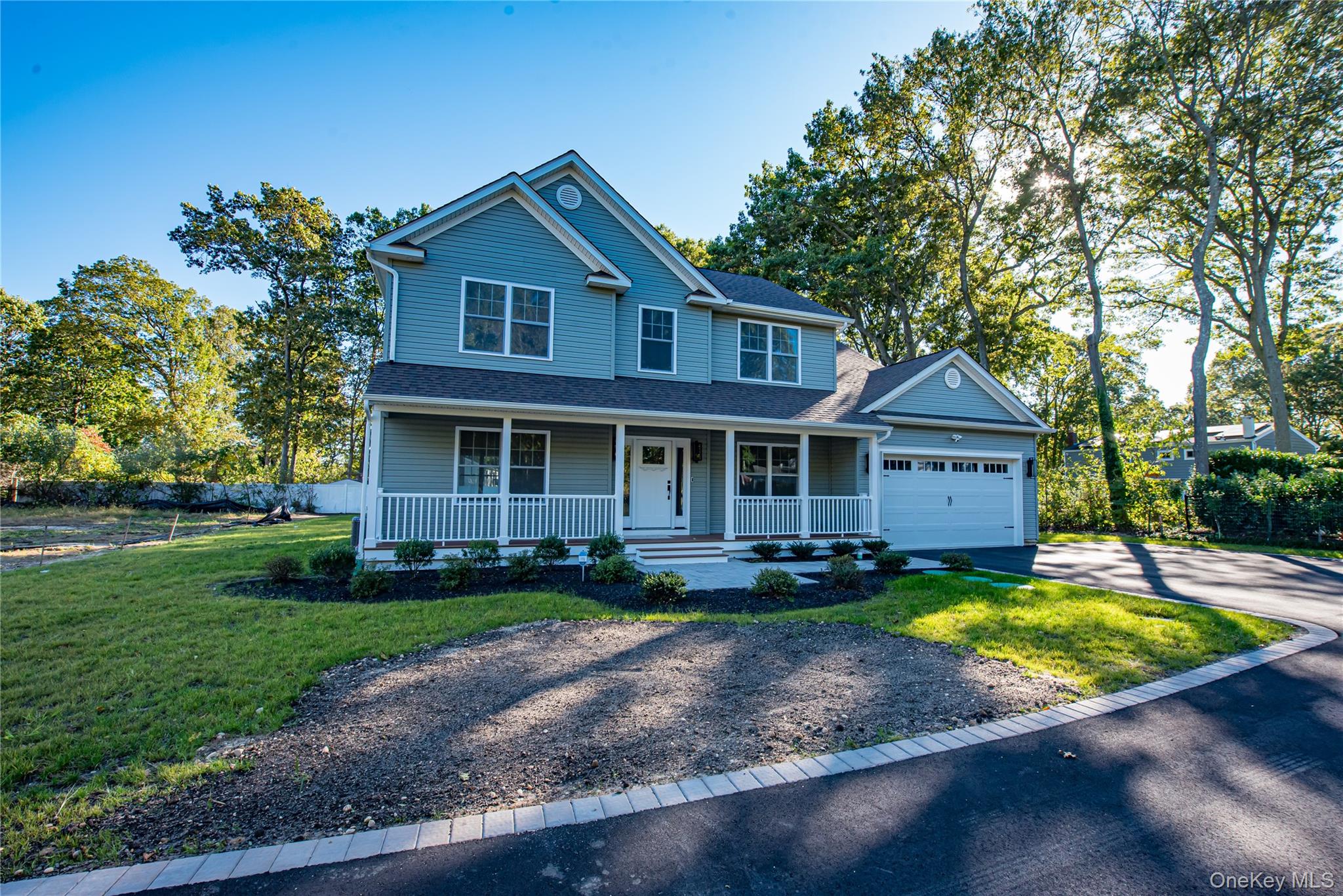 64 Blydenburgh Road Centereach, NY 11720 - Photo 5 of 44 View of front facade featuring a porch, driveway, a shingled roof, and an attached garage. For Marketing Purposes!