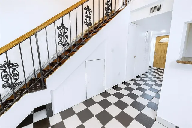 a view of a hallway with wooden floor and black white checkered floor