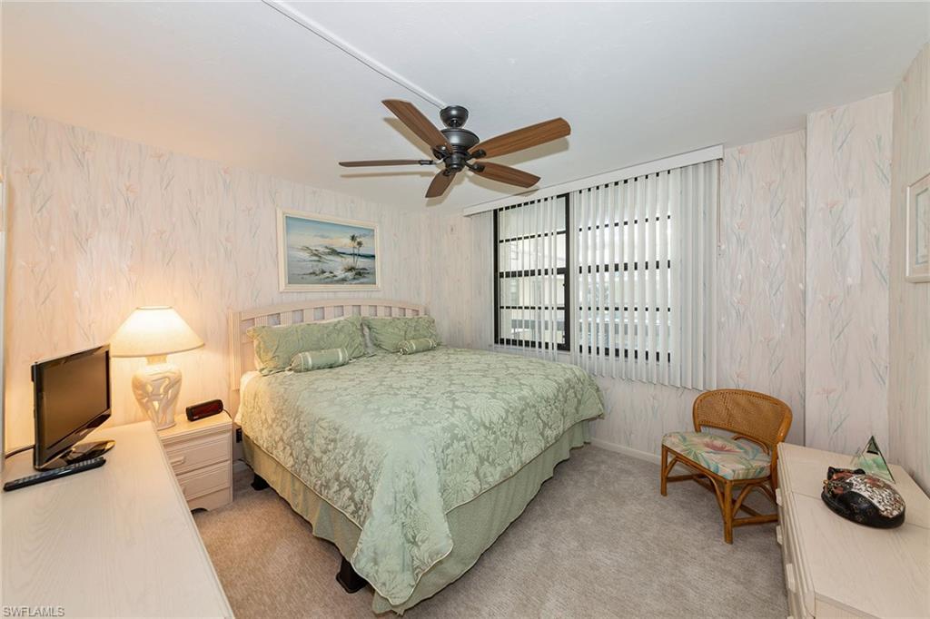 591 Seaview Court, Unit A306 Marco Island, FL 34145 - Photo 11 of 16 a bedroom with a bed and a chandelier