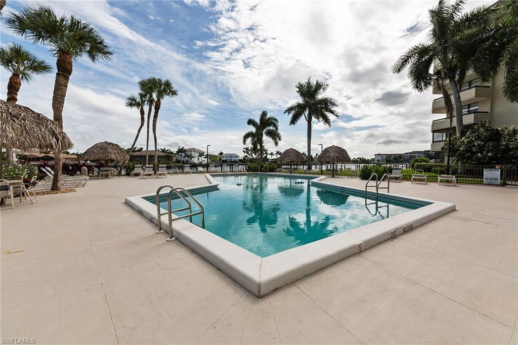 591 Seaview Court, Unit A306 Marco Island, FL 34145 - Photo 15 of 16 a view of swimming pool with outdoor seating and plants