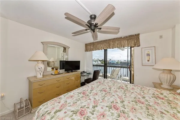 a bedroom with a bed a large window with table and chairs