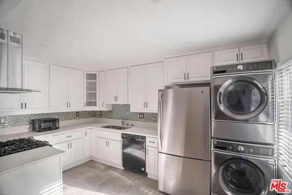 a kitchen with a refrigerator sink stove and cabinets