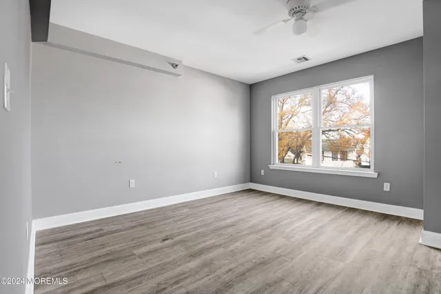 wooden floor in an empty room with a window