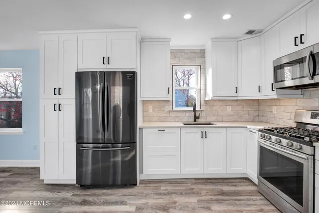 a kitchen with stainless steel appliances granite countertop a refrigerator stove and sink