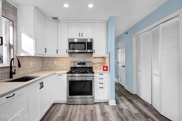 a kitchen with stainless steel appliances a stove a sink and a microwave