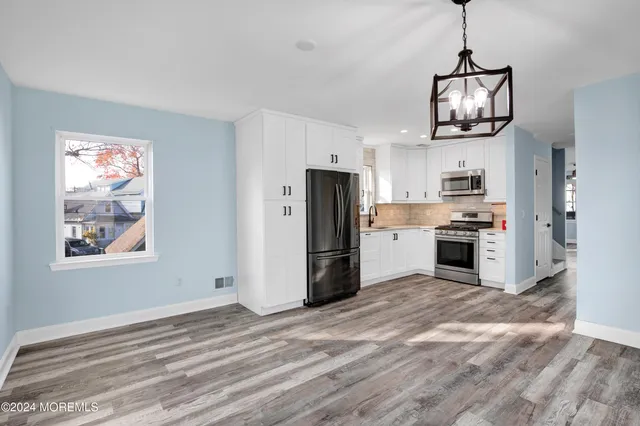 a kitchen with stainless steel appliances granite countertop a refrigerator and a stove top oven