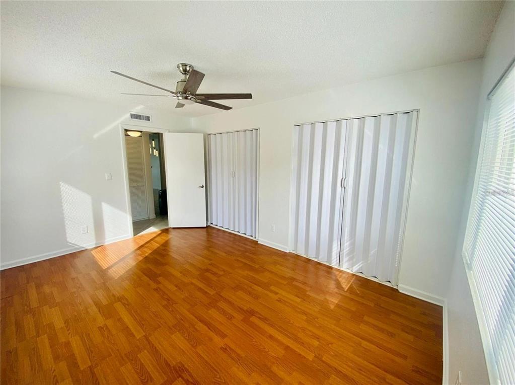633 North Keene Road, Unit C Clearwater, FL 33755 - Photo 12 of 20 a view of a big room with wooden floor ceiling fan and windows