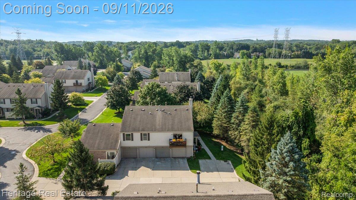 3088 High Pointe Ridge Road Lake Orion, MI 48359 - Photo 26 of 31 Residential property featuring a two-story structure with attached garages, surrounded by mature trees and manicured landscaping