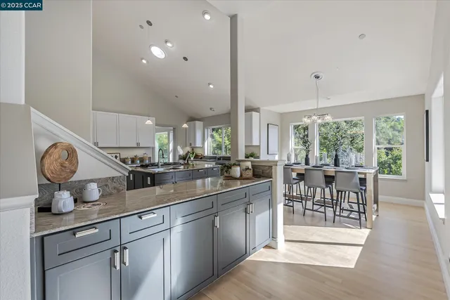 a kitchen with stainless steel appliances granite countertop a table chairs and wooden floor