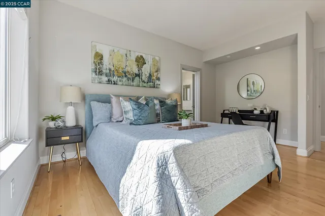 a bedroom with a bed and painting on the wall