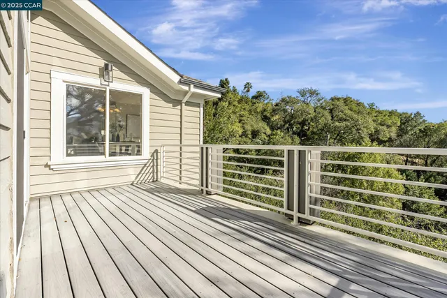a view of a balcony with wooden floor and fence