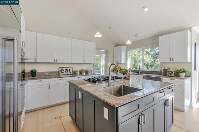 a kitchen with a sink white cabinets and white appliances
