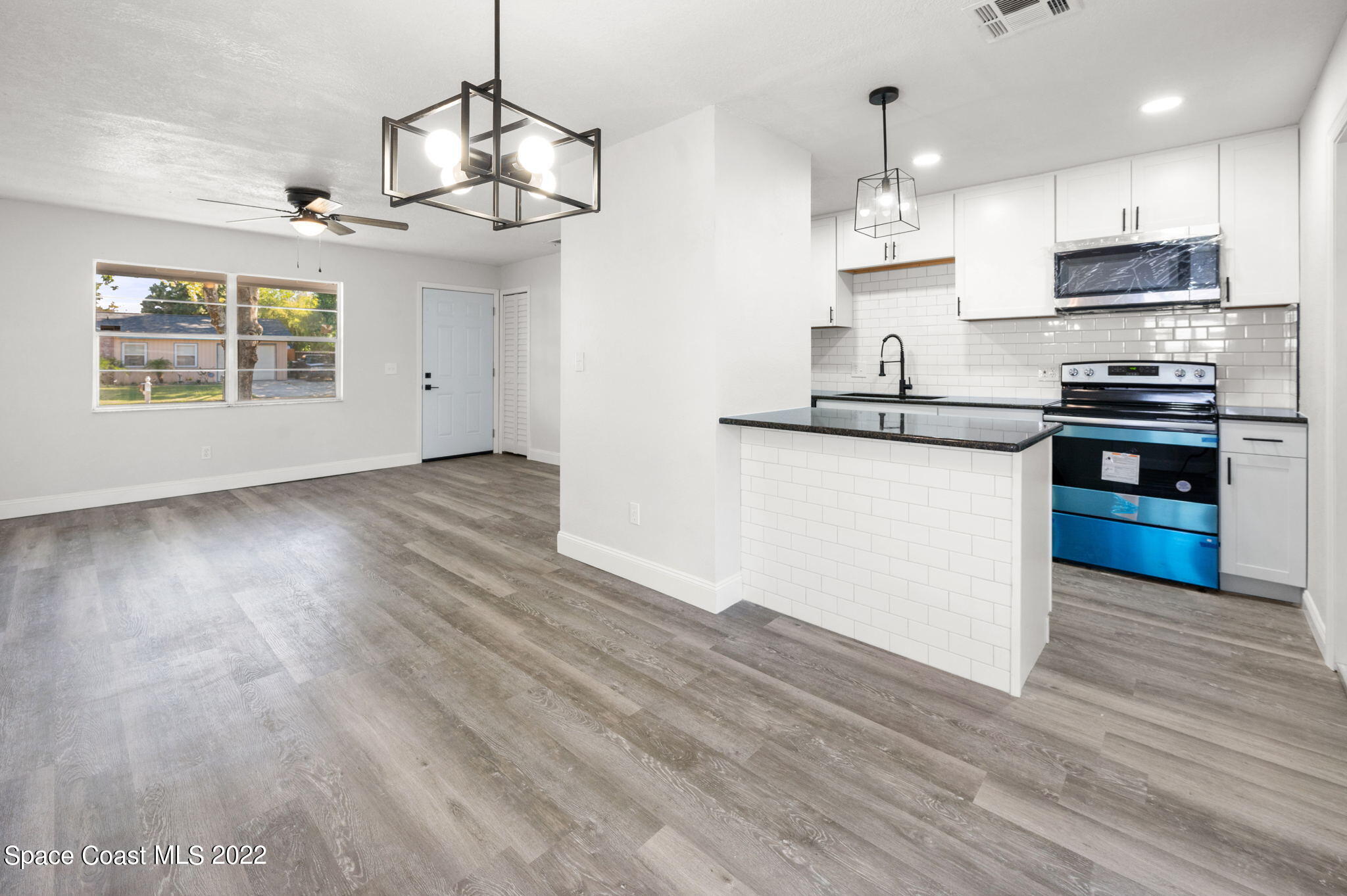2856 Lancaster Road Melbourne, FL 32935 - Photo 6 of 22 a kitchen with stainless steel appliances granite countertop a sink a stove and a wooden floors