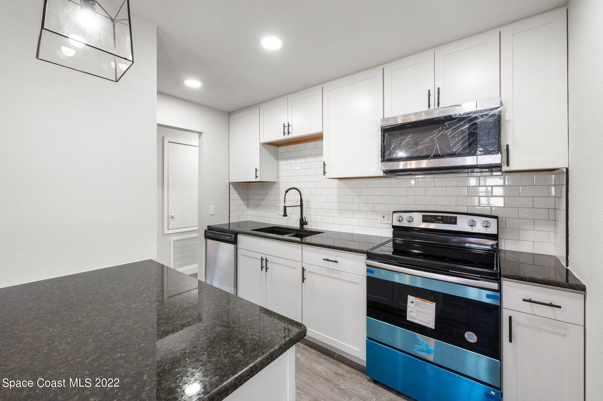 2856 Lancaster Road Melbourne, FL 32935 - Photo 7 of 22 a kitchen with stainless steel appliances granite countertop a stove a sink and a microwave