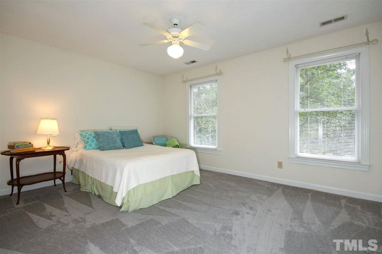 5216 Caber Road Raleigh, NC 27613 - Photo 14 of 25 a spacious bedroom with a bed and a window