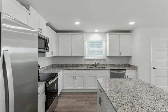 a kitchen with stainless steel appliances granite countertop a stove a sink and a refrigerator