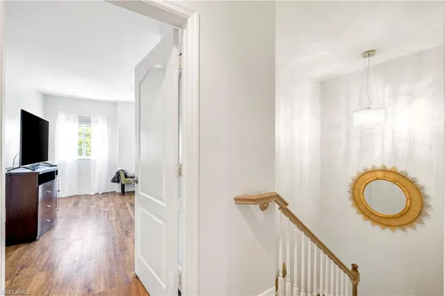 a view of a hallway with wooden floor and furniture
