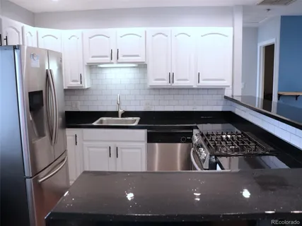 a view of kitchen with refrigerator stove and sink