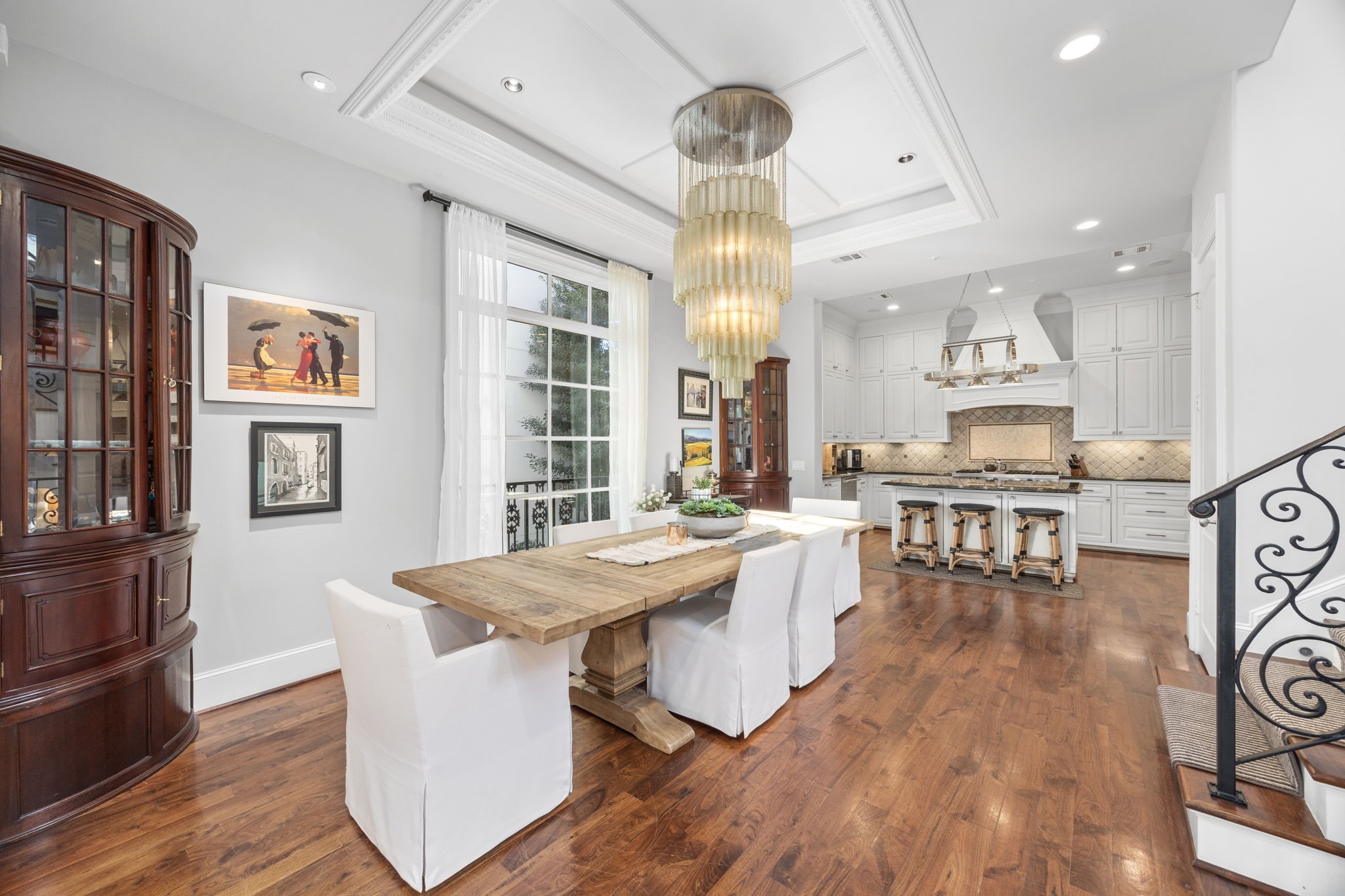 1723 Sunset Boulevard Houston, TX 77005 - Photo 14 of 50 Warm hardwood floors and designer lighting elevate the dining space, creating an inviting setting that feels equally suited for everyday meals or celebrations.