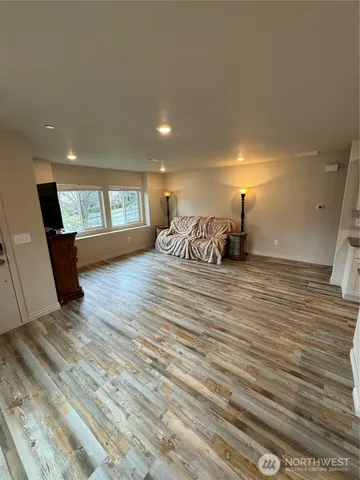 a bedroom with a bed and wooden floor