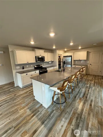 a kitchen with stainless steel appliances granite countertop a stove a sink a refrigerator and cabinets