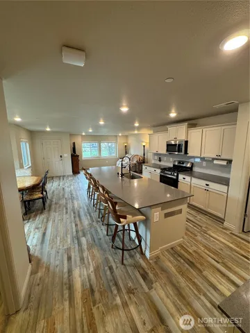 a living room with stainless steel appliances furniture a kitchen view and a kitchen counter top