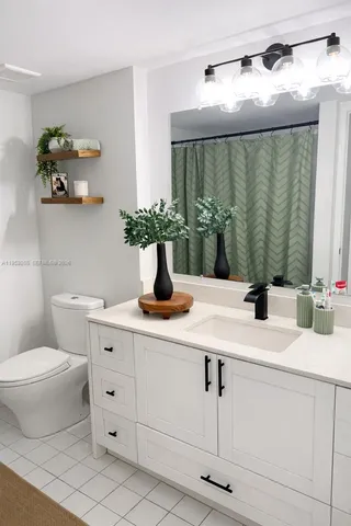 a bathroom with a double vanity sink toilet and mirror