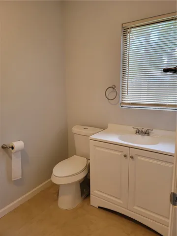 a bathroom with a toilet sink vanity and mirror