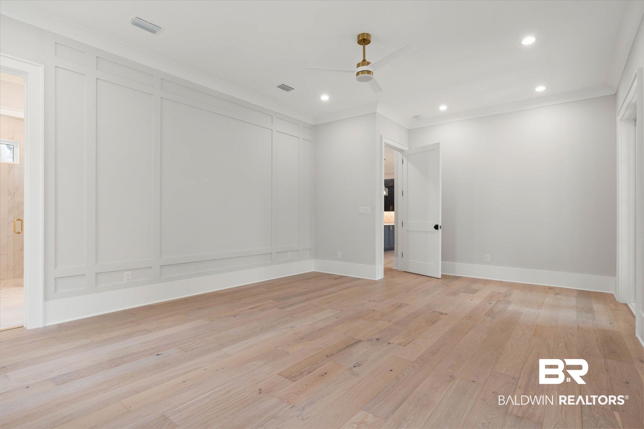 853 Inlet Circle Gulf Shores, AL 36542 - Photo 18 of 55 Unfurnished room with visible vents, ornamental molding, a decorative wall, ceiling fan, and light wood finished floors