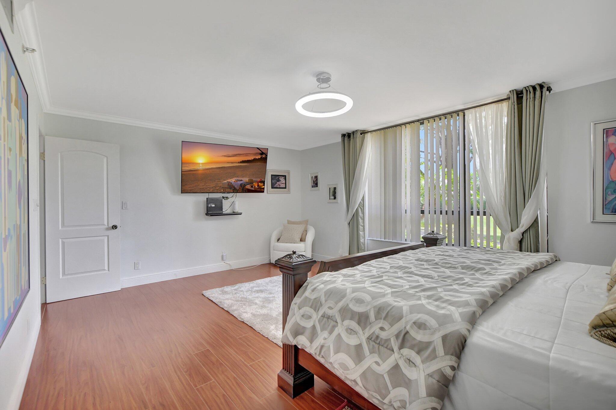 7194 Promenade Drive, Unit 102 Boca Raton, FL 33433 - Photo 27 of 56 a bedroom with a bed and a flat screen tv