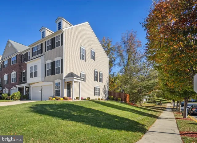 a view of a white house with a big yard and large trees