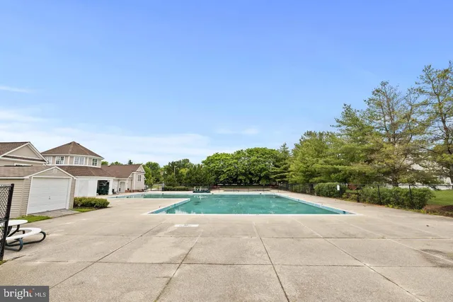 a view of a white house with a big yard and large trees