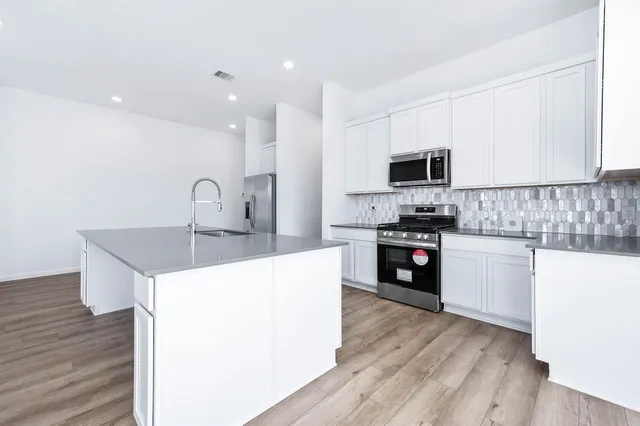 a kitchen with white cabinets granite counter tops and a window