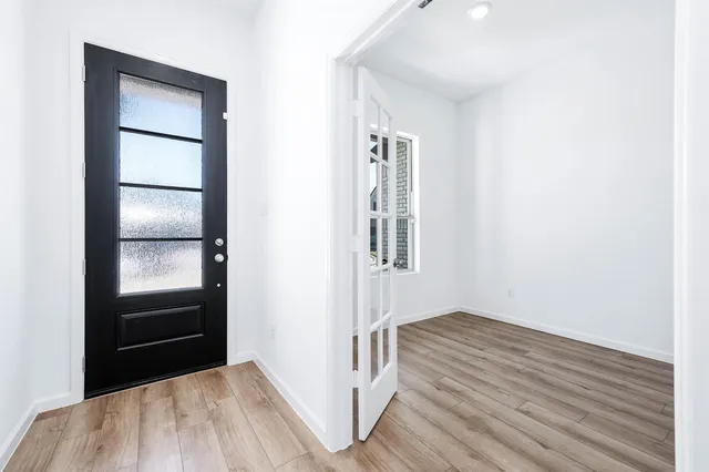 a view of a kitchen with wooden floor and a refrigerator