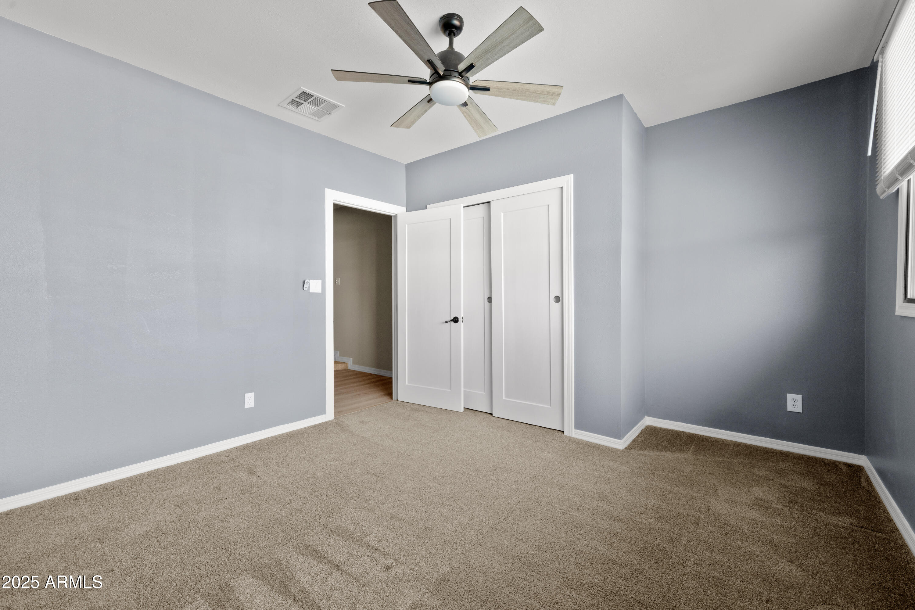 2715 South Rita Lane Tempe, AZ 85282 - Photo 16 of 30 an empty room with closet and a chandelier fan