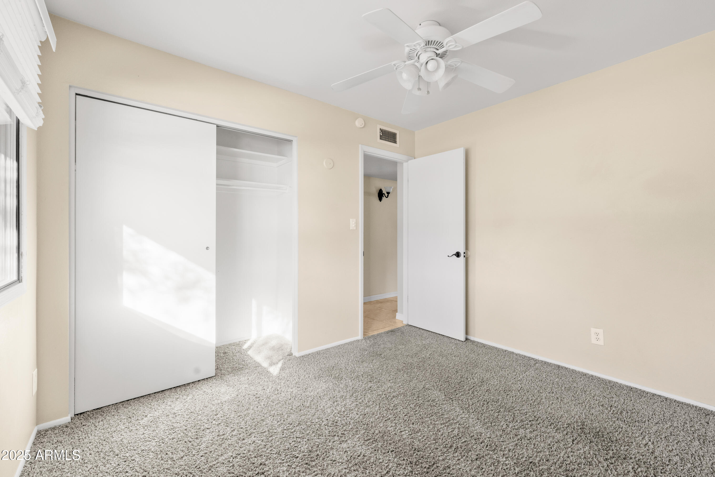 2715 South Rita Lane Tempe, AZ 85282 - Photo 25 of 30 an empty room with a ceiling fan and a window