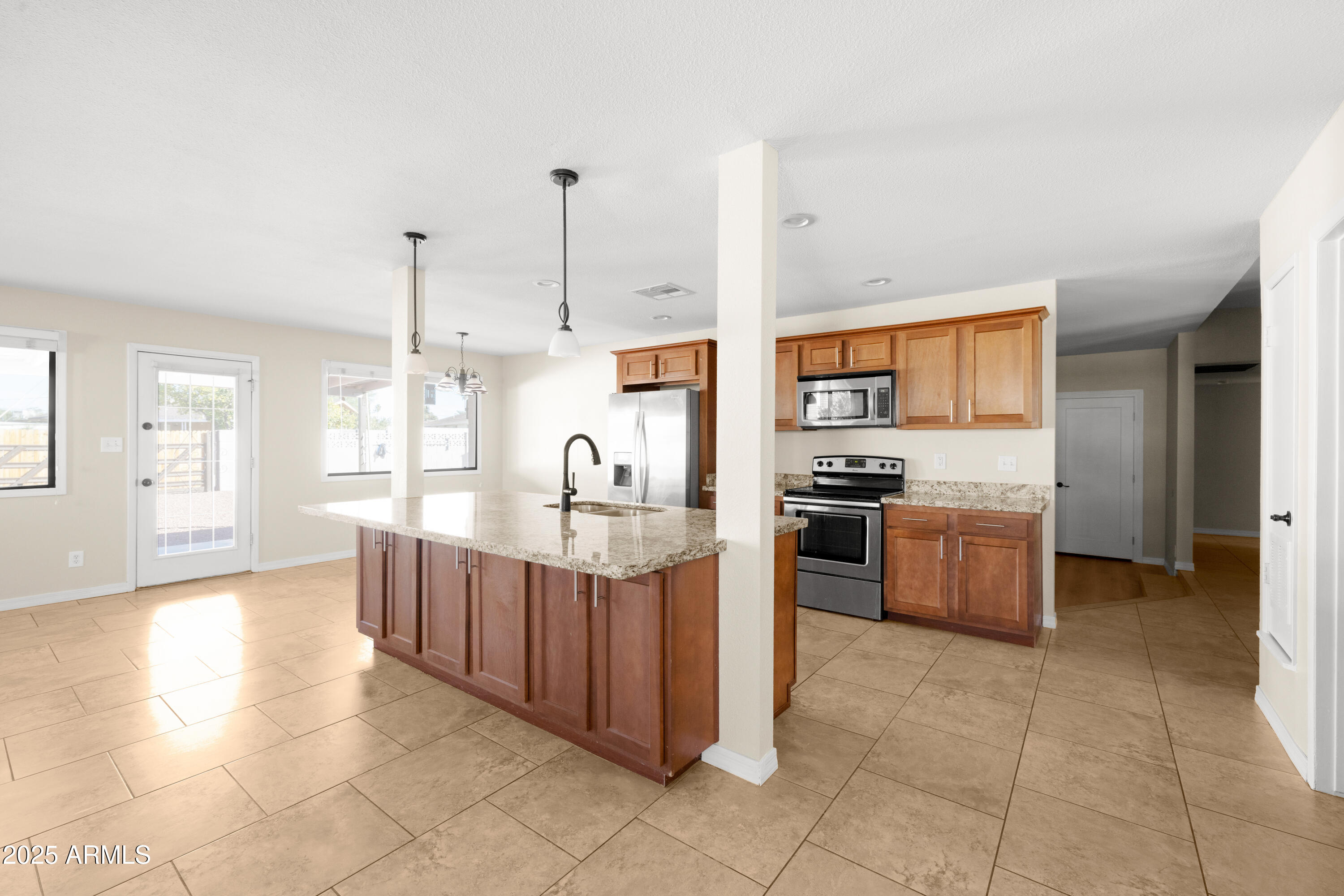 2715 South Rita Lane Tempe, AZ 85282 - Photo 7 of 30 a kitchen with stainless steel appliances kitchen island granite countertop a stove a sink and a refrigerator