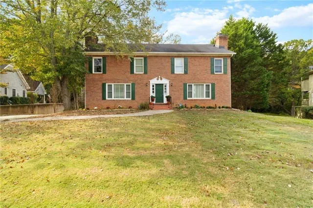 a front view of house with yard and trees around